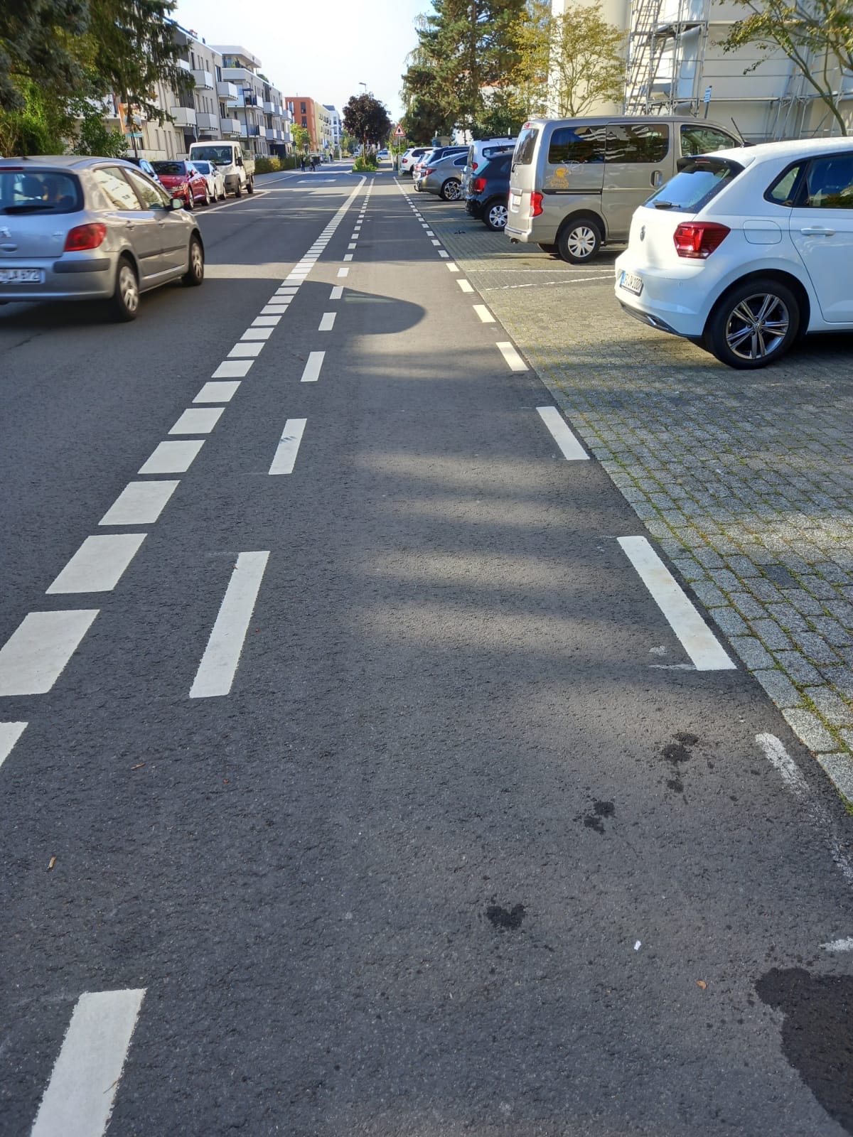Ein Fußweg und ein Fahrradweg verlaufen nebeneinander, die nur durch optische Striche voneinander abgegrenzt sind.